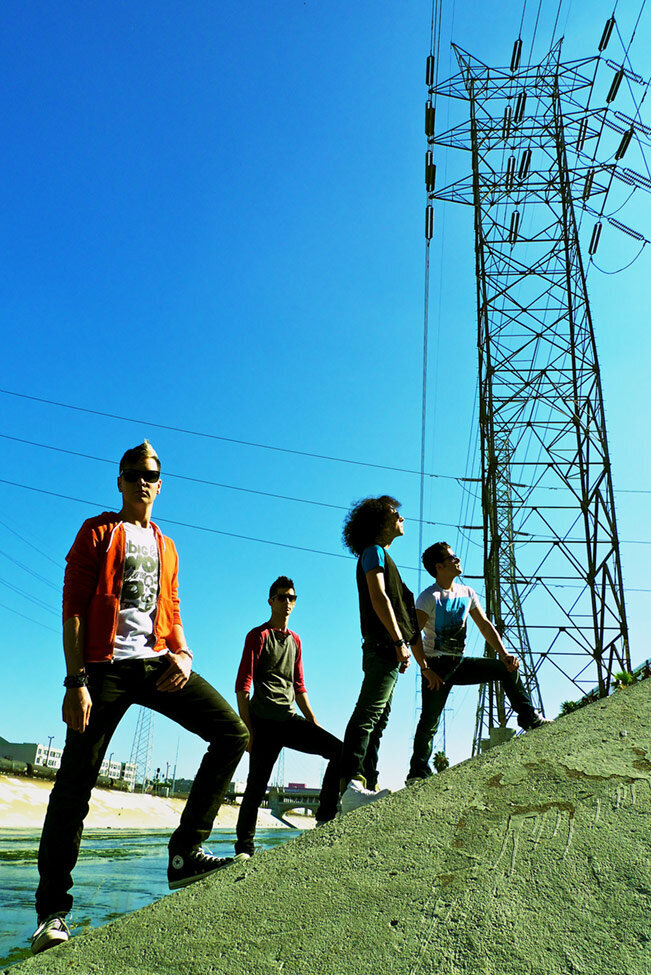 Band photo of Faber Drive all four members standing staggered on incline of reservoir Los Angeles