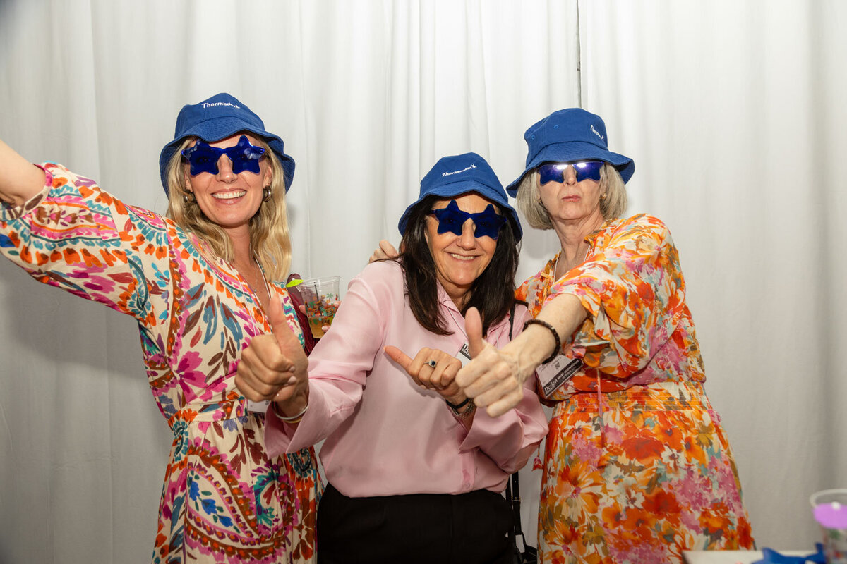 Three women in blue hats and star sunglasses