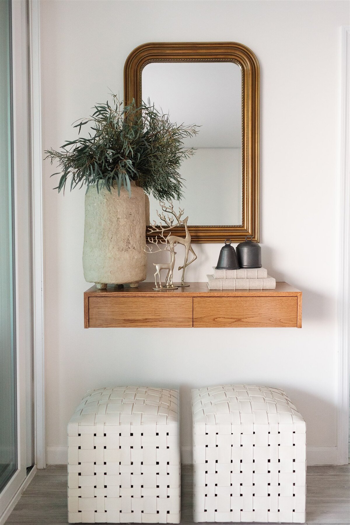 Accents on wooden shelf and gold mirror