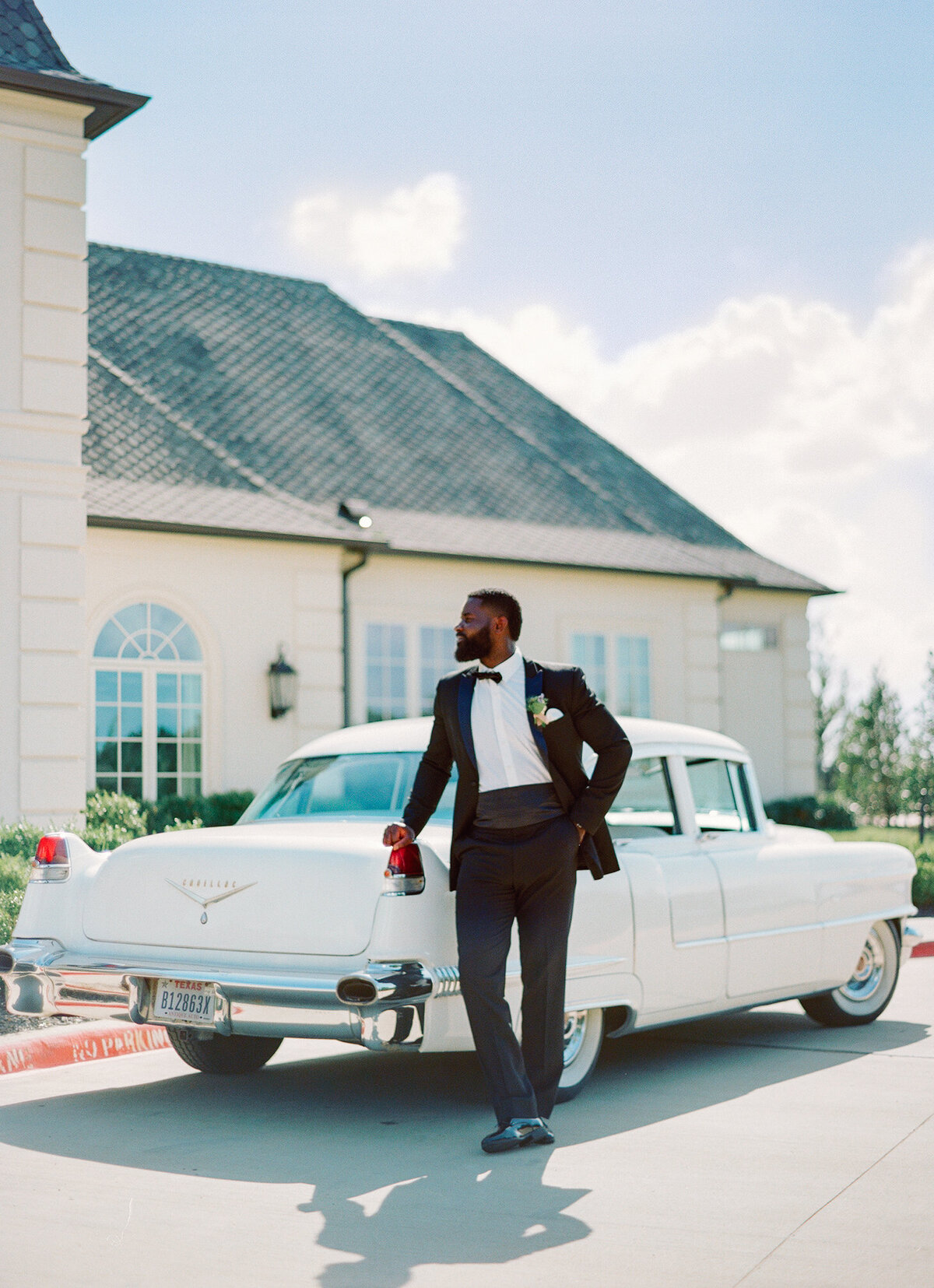 Black man stands with classic car