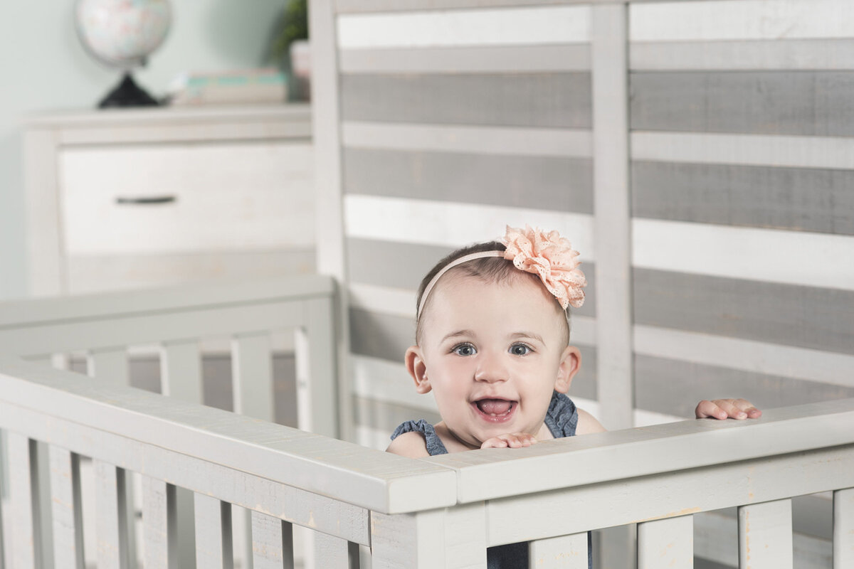 Advertising photograph of a child model on set with a crib