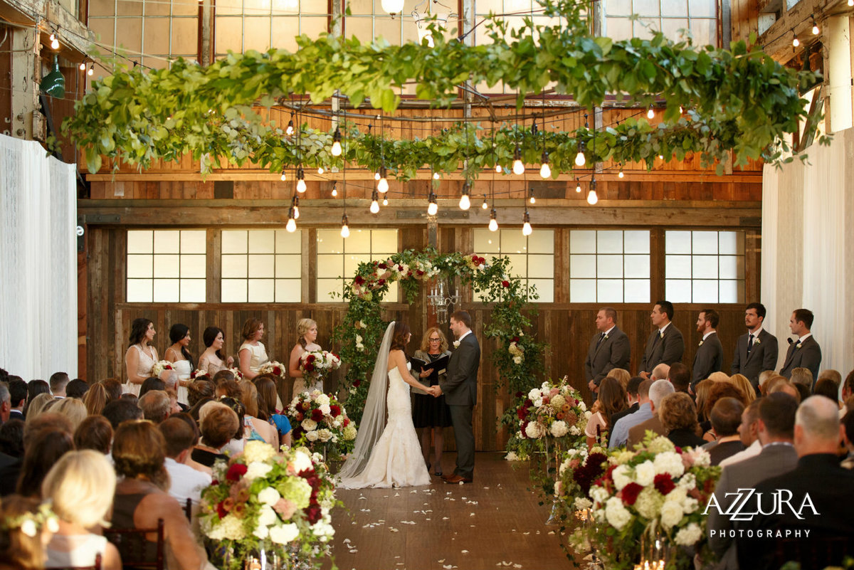 wedding at Sodo Park with large greenery wreath in ceiling at Sodo Park Seattle