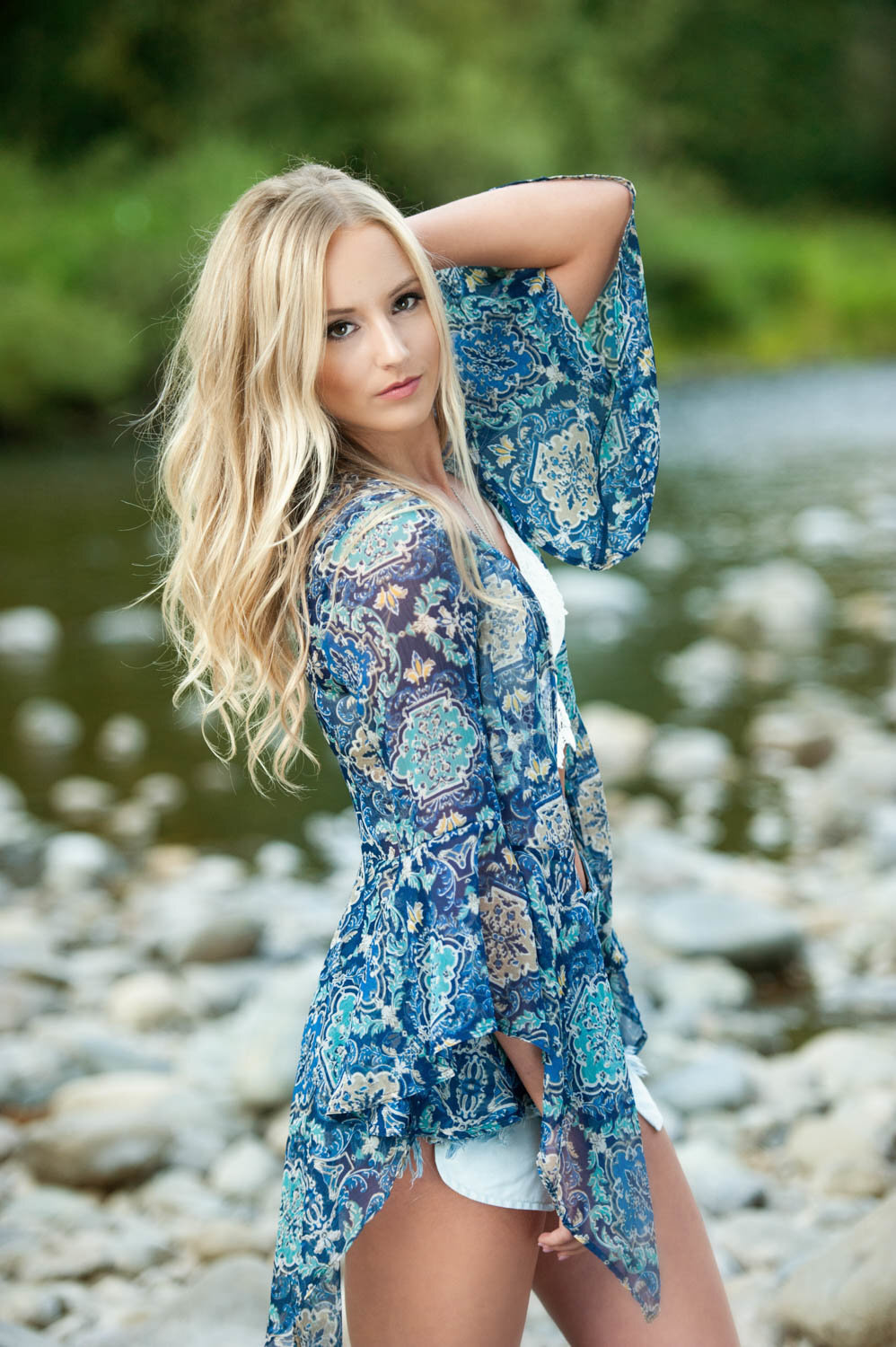 senior portrait of girl with patterned shirt in river