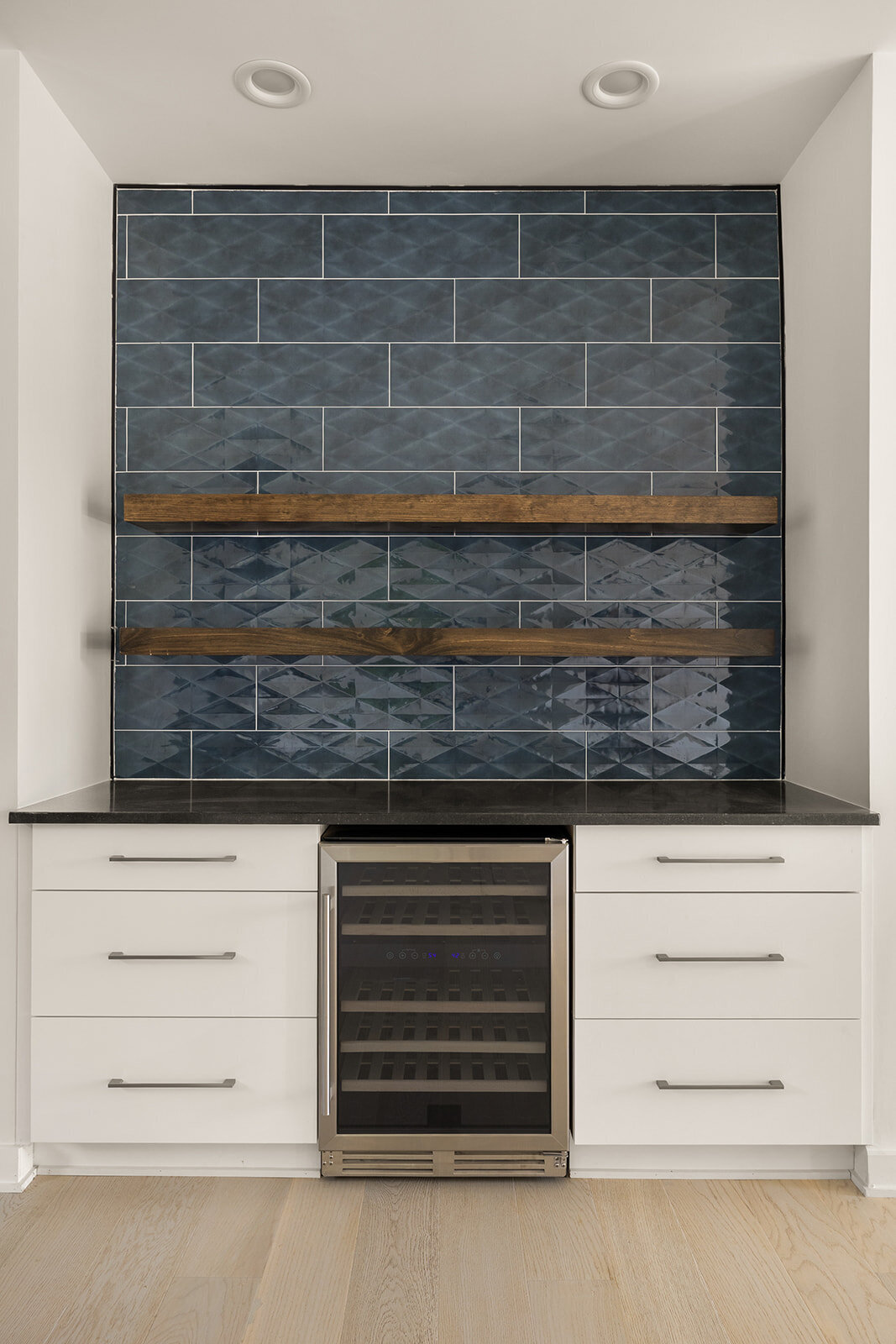 Blue tile in kitchen with white cabinetry