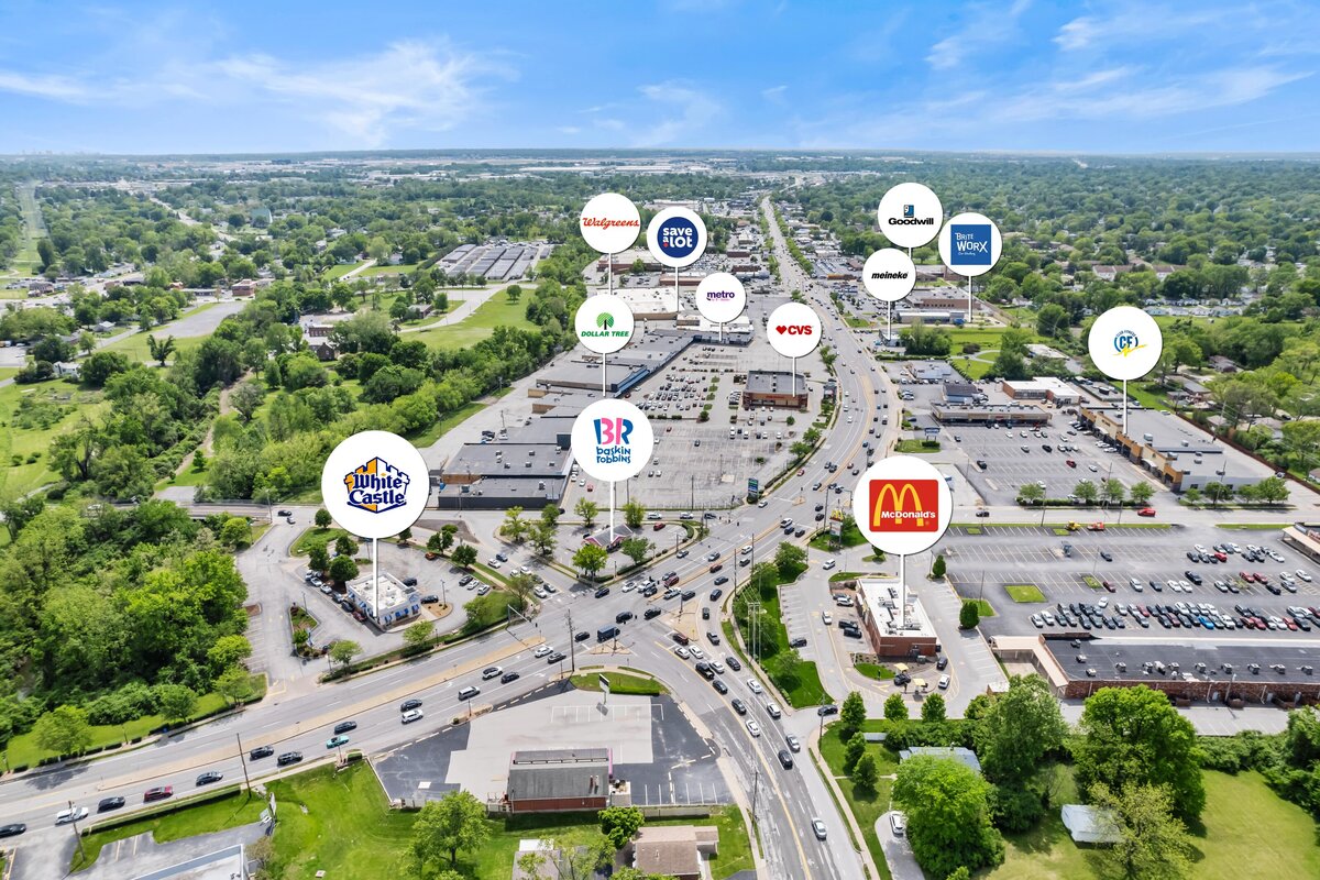 Aerial commercial real estate photograph of a shopping center with nearby stores and restaurants labeled with logos.