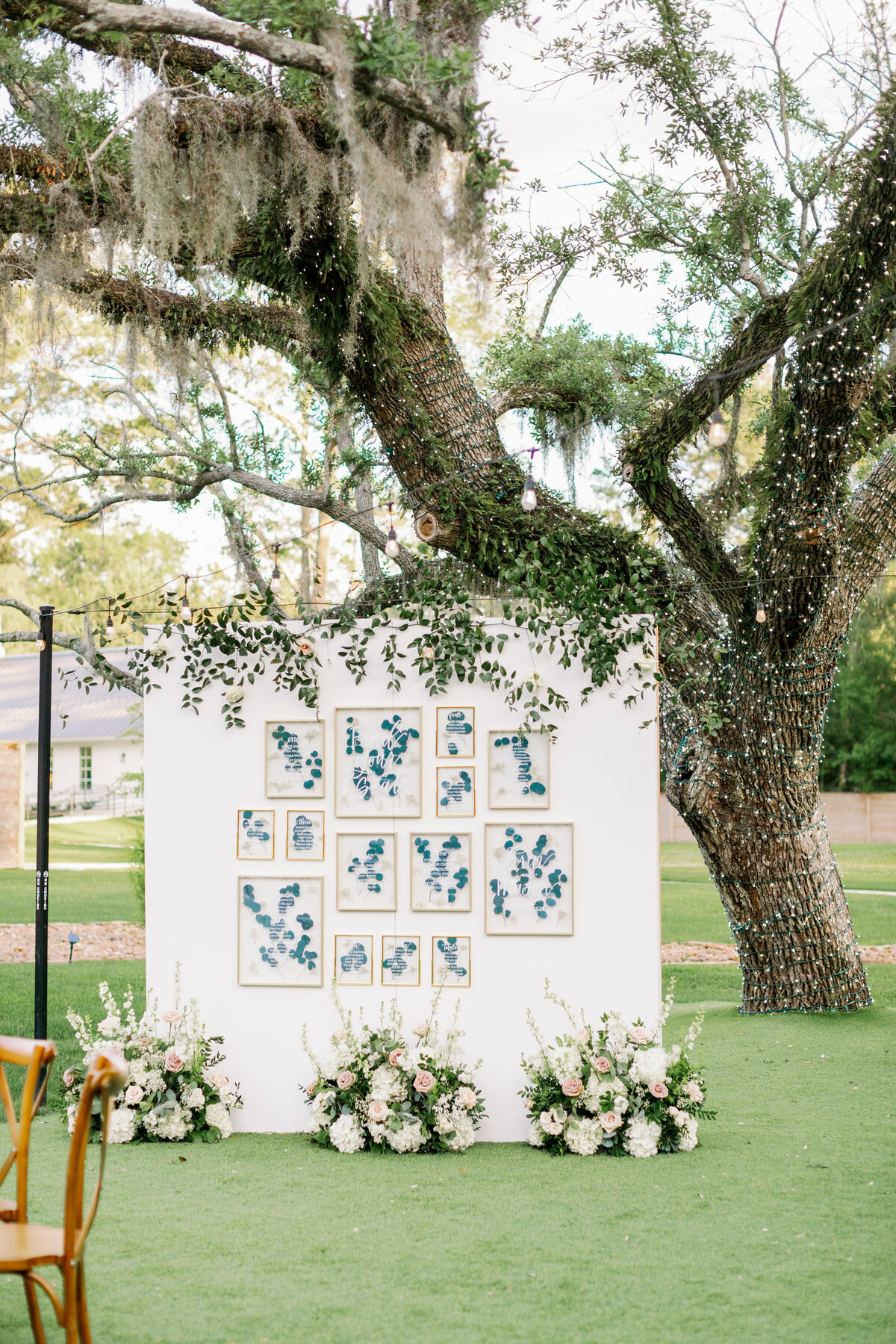 Elegant white and blue outdoor wedding backdrop decorated with white florals and greenery