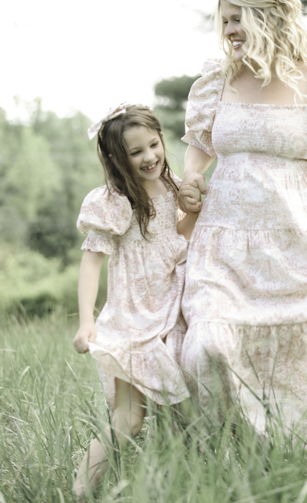 smiling daughter holding her mothers hand