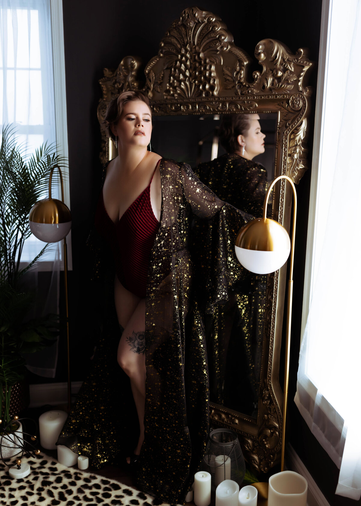 woman with short hair in red lingerie and luxe rob in front of mirror boudoir