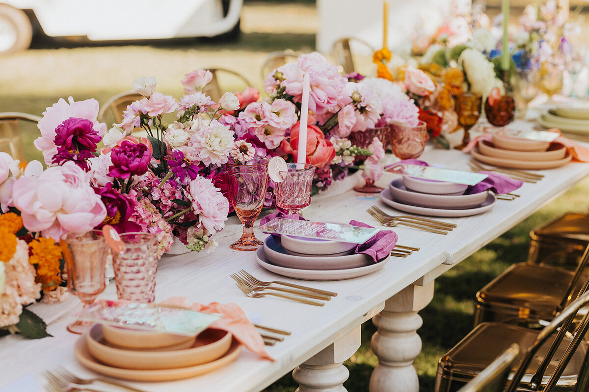 Editorial wedding tablescape featuring bold, colorful florals and modern place settings with layered textures and luxury event styling in South Carolina.
