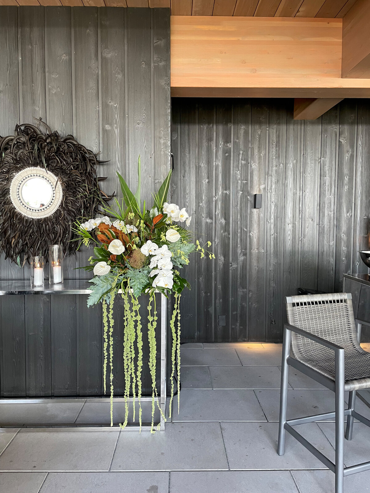 An exotic flower arrangement with draped greenery sits on a bar corner at a Montreal wedding. 