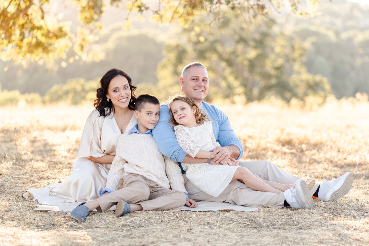 bay area family snuggling on a blanket on a hillside