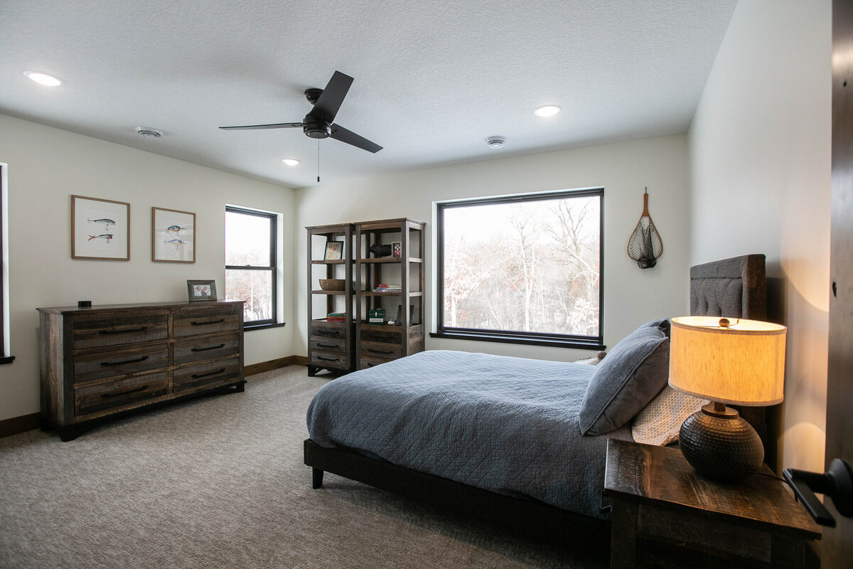 Custom bedroom with dark wood accents and neutral tones in Elk River home by Cornerstone Custom Builds