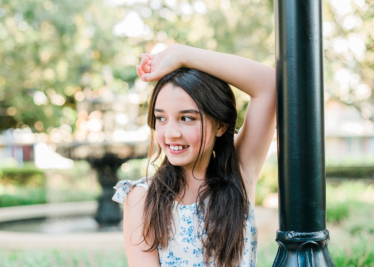 Little girl posing with her arm over her head and smiling