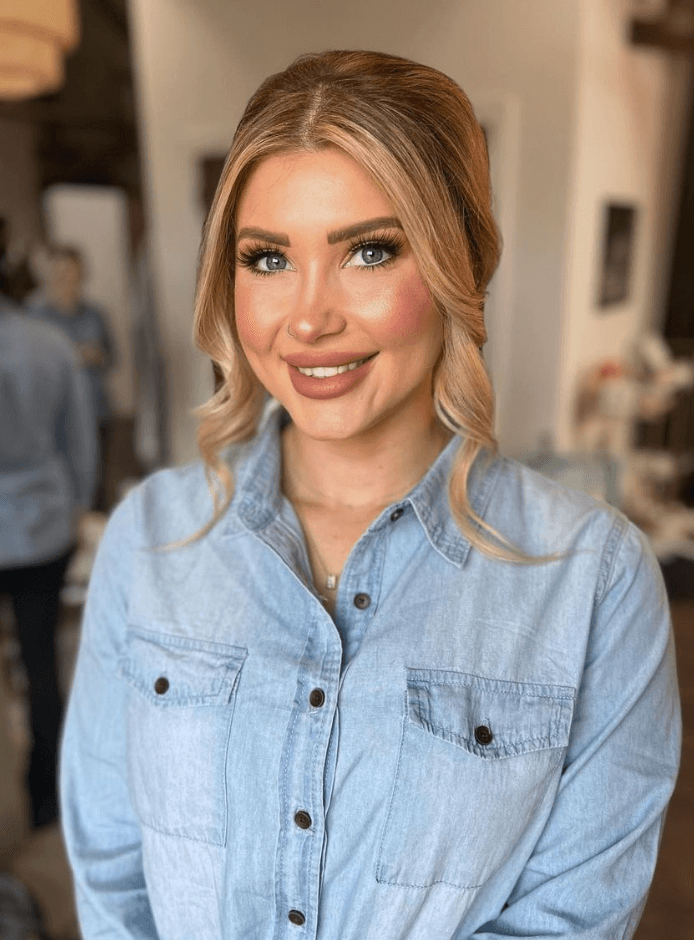 Smiling woman with soft curls and natural glam makeup, styled in San Antonio for a daytime event by Mistique Makeup