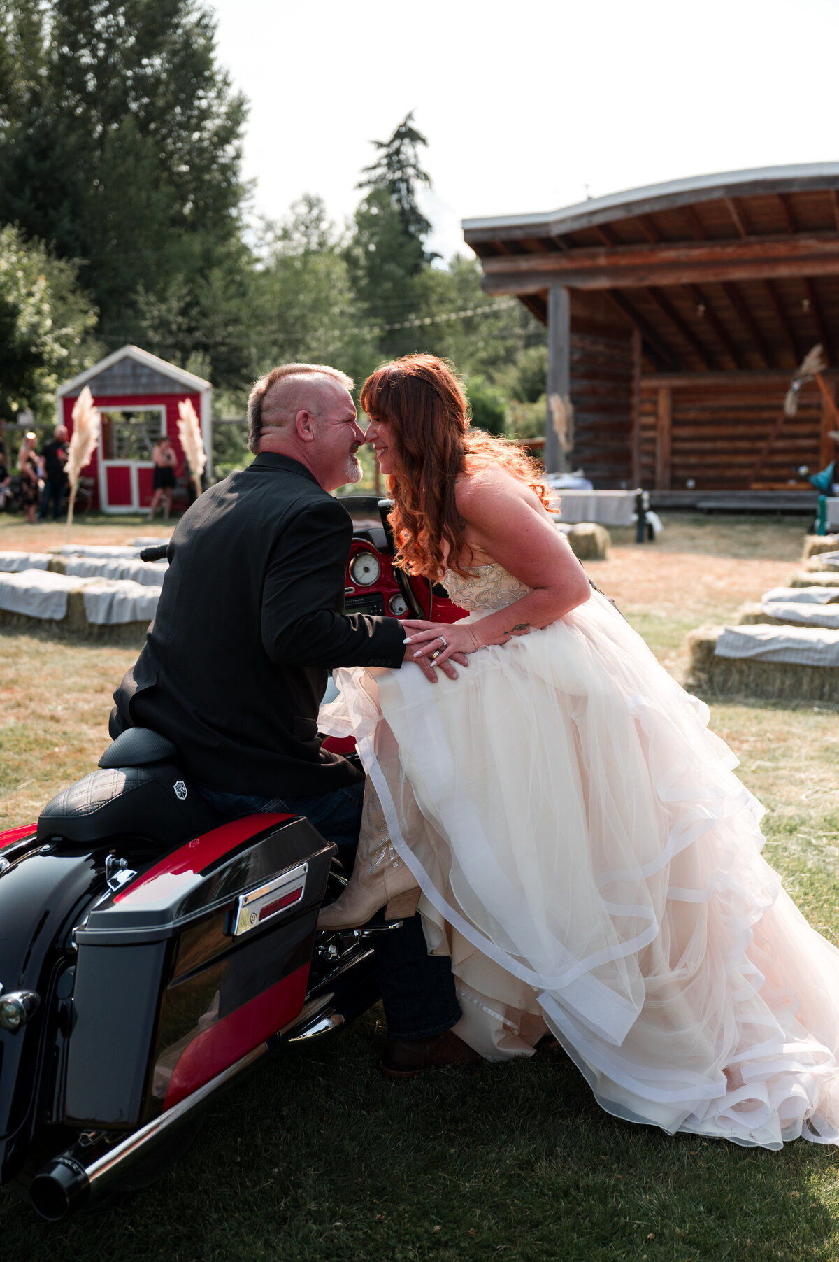 Bride and groom pose on motorcylcle for wedding photos