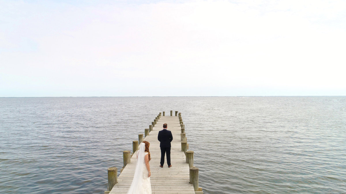 photo of bride and groom on the dock before first look from wedding at Lombardi's on the Bay