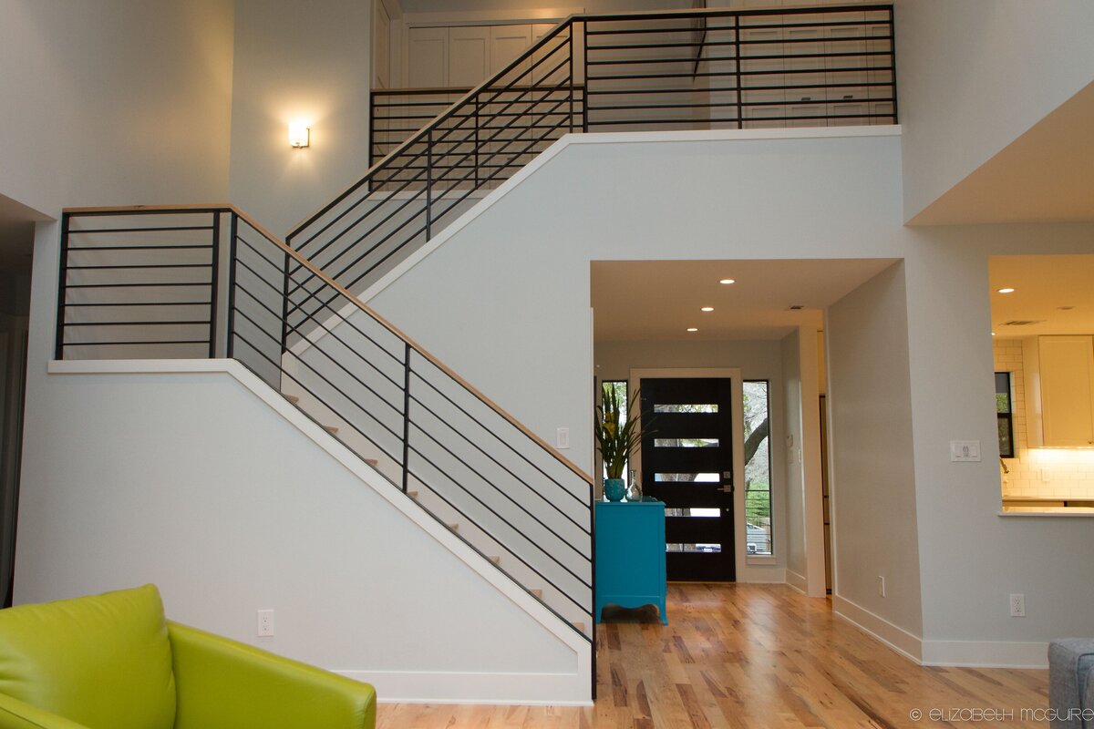 two level staircase with iron railing and hard wood floors.