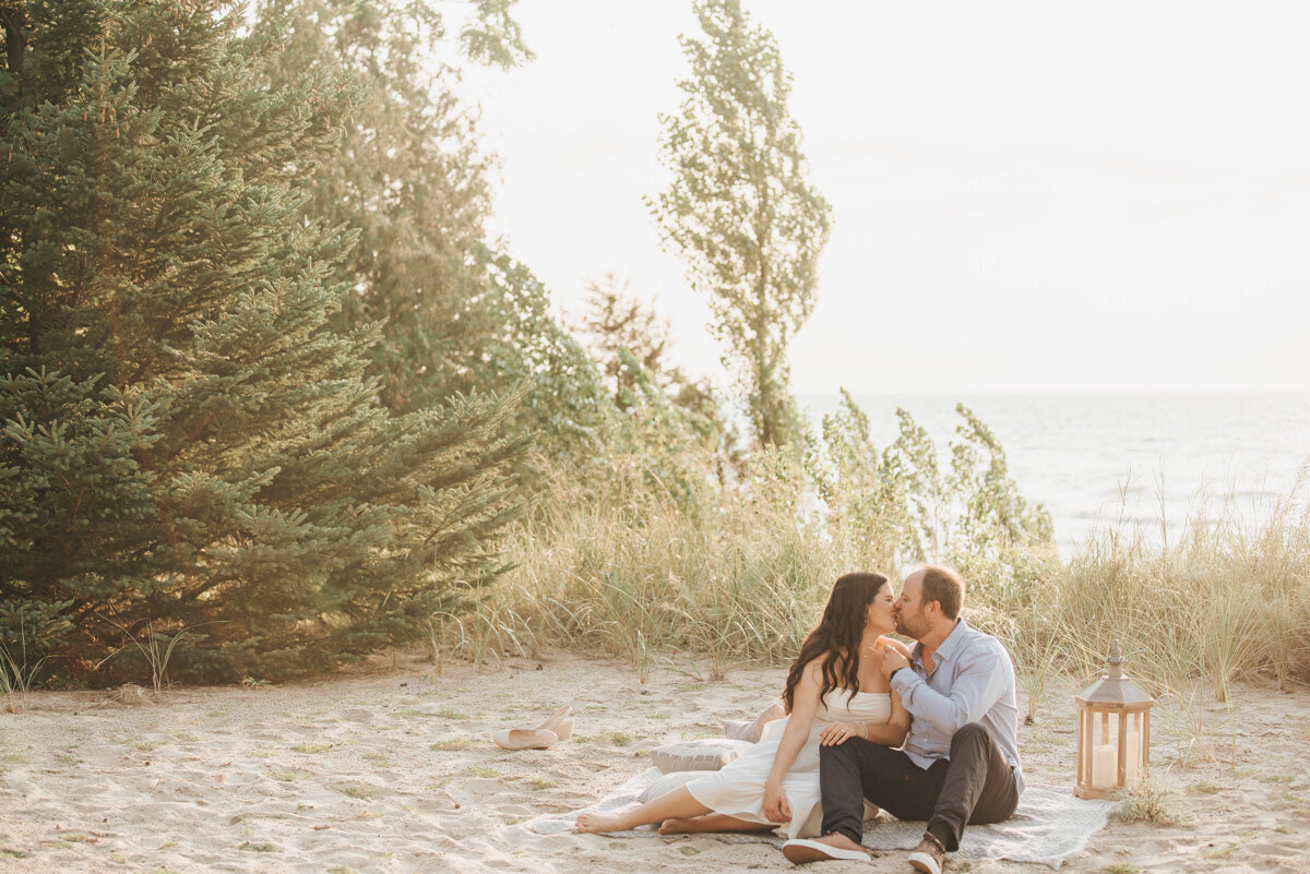 Couple posing for photos on the beach at their Grand Bend Ontario Engagement Photographer NovaMarkina Photography
