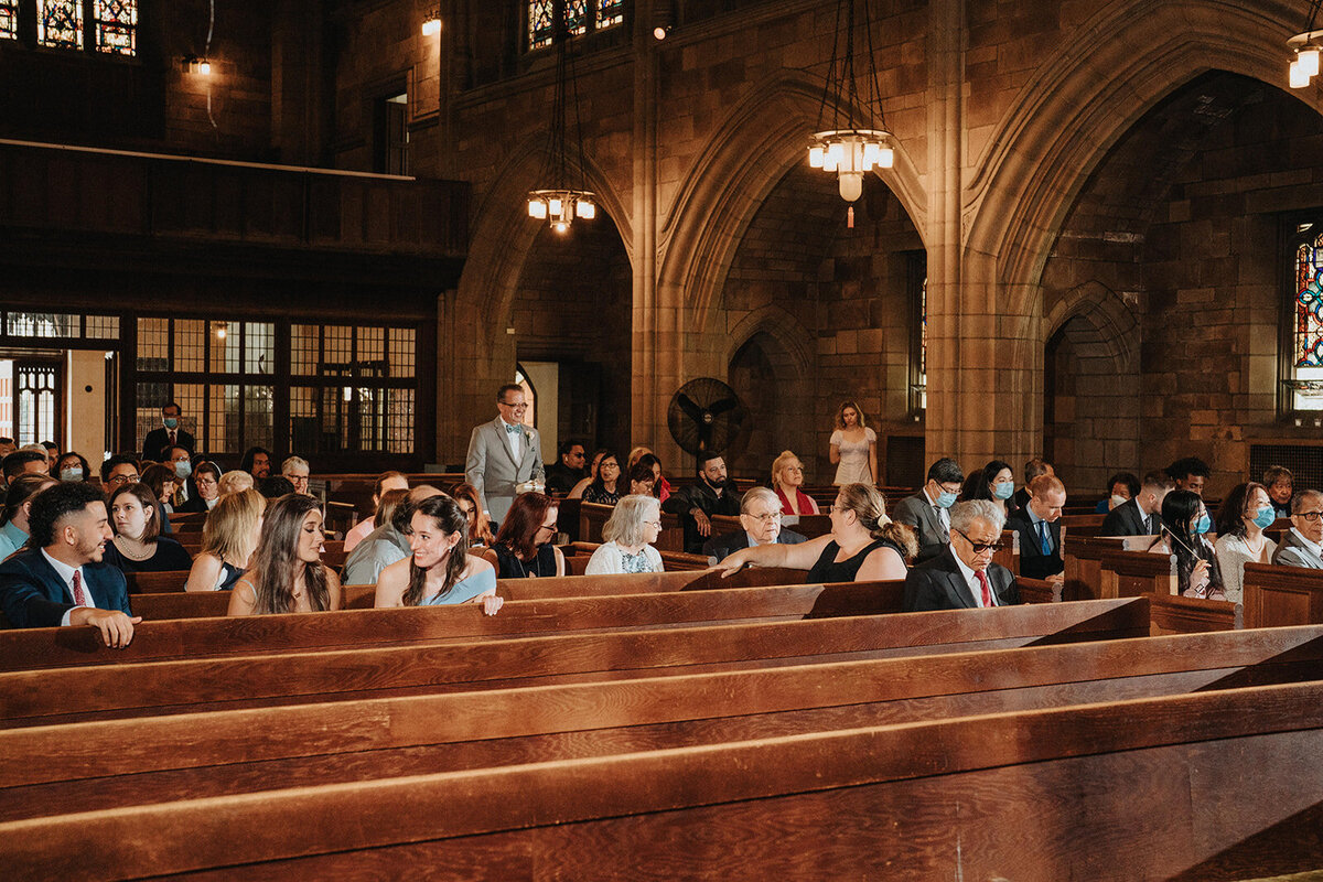 NJ wedding guests sitting at a wedding in a cathedral