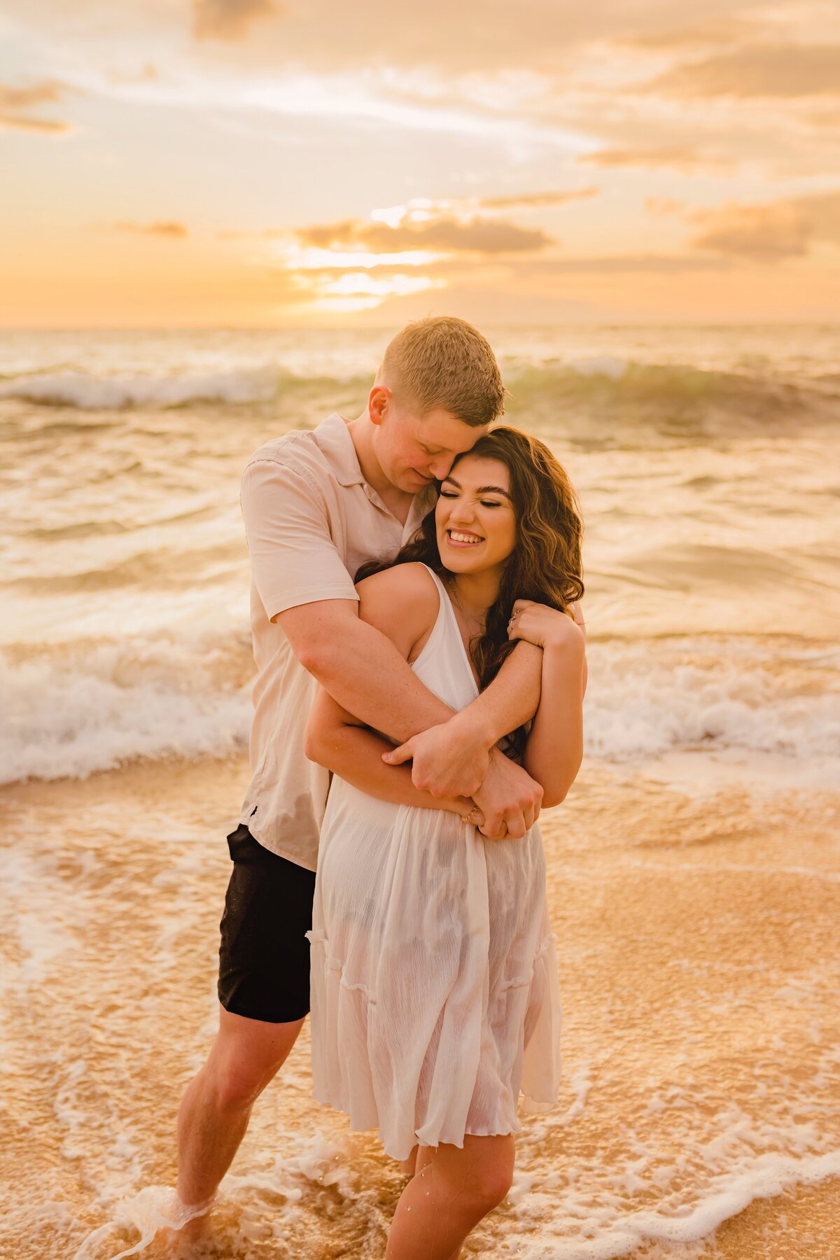 man wraps his arms around his fiance during their engagement photoshoot at golden hour