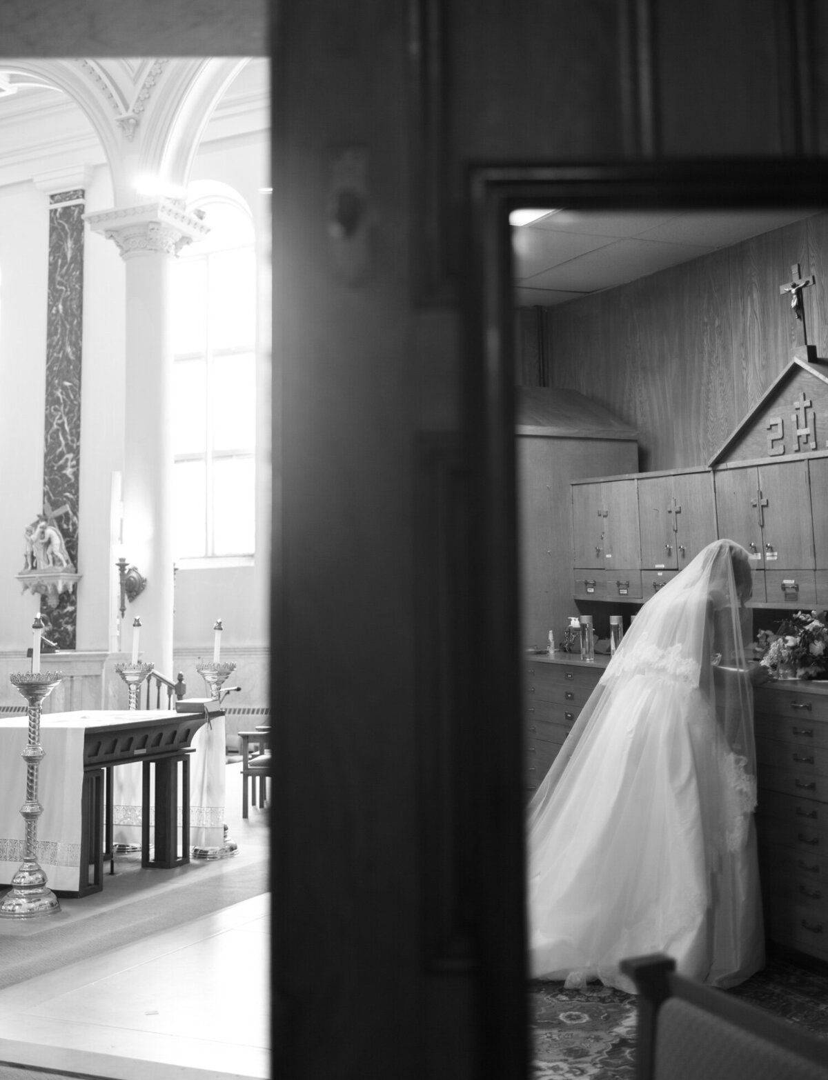Unique, creative wedding photography in Detroit shows a bride signing marriage license, reflected in mirror with St. Peter and Paul cathedral