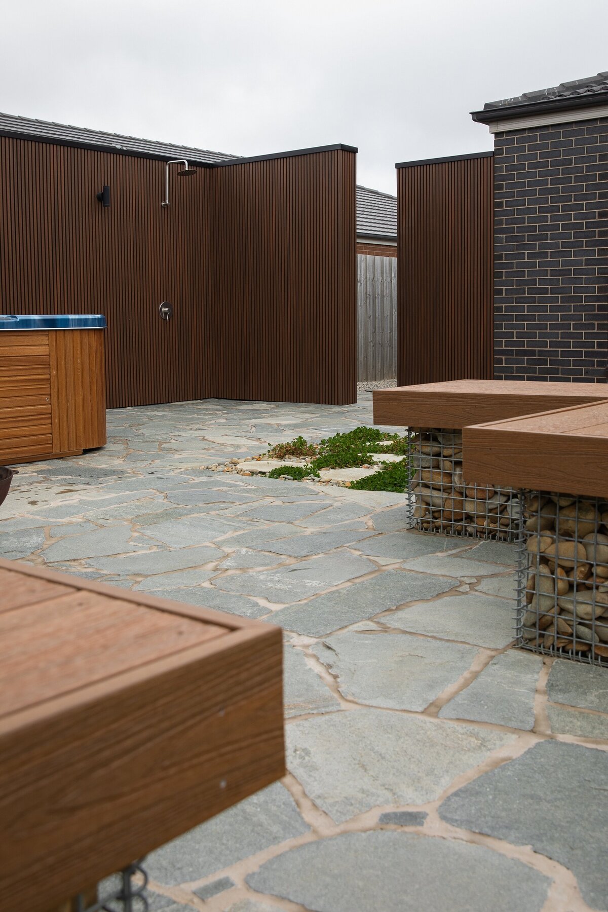 Rock work seating and paving in outdoor space design by total landscapes & design Warrnambool. 