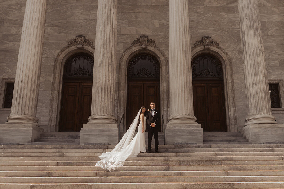 Couple standing on steps of a neoclassical building.