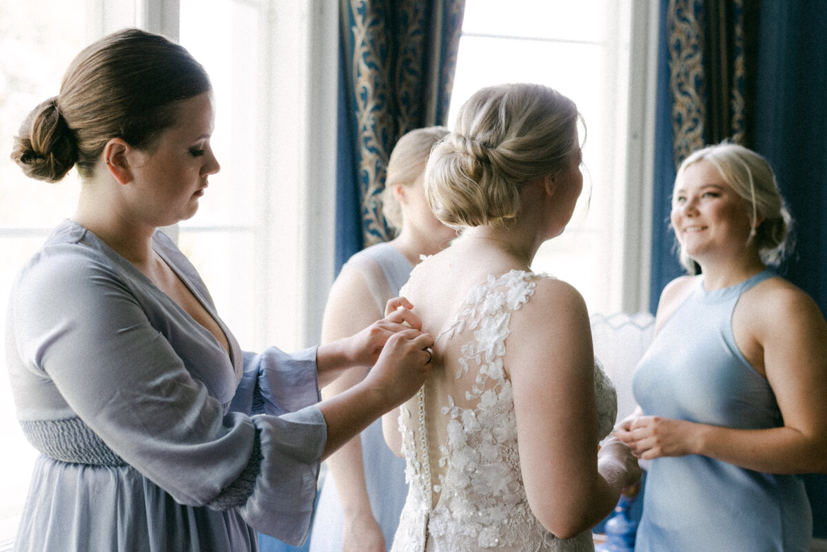 Bridesmaids helping the bride t get ready in an image photographed by wedding photographer Hannika Gabrielsson.