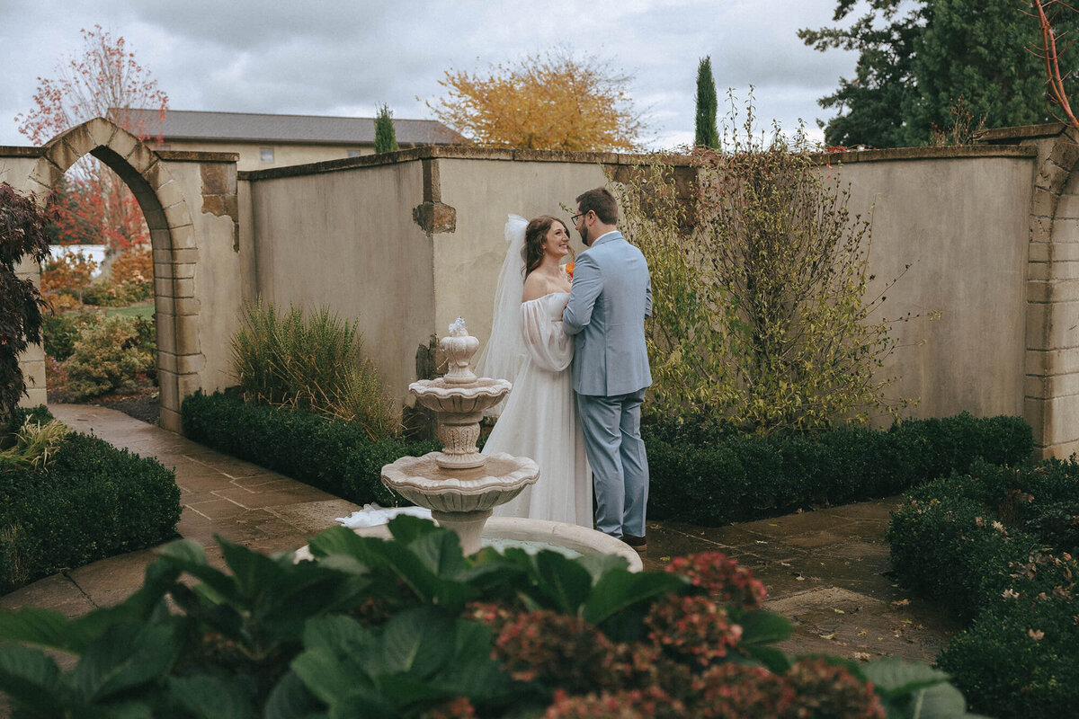 Bride and groom embrace during first looks in a garden at Chateau wedding venue in Oregon.