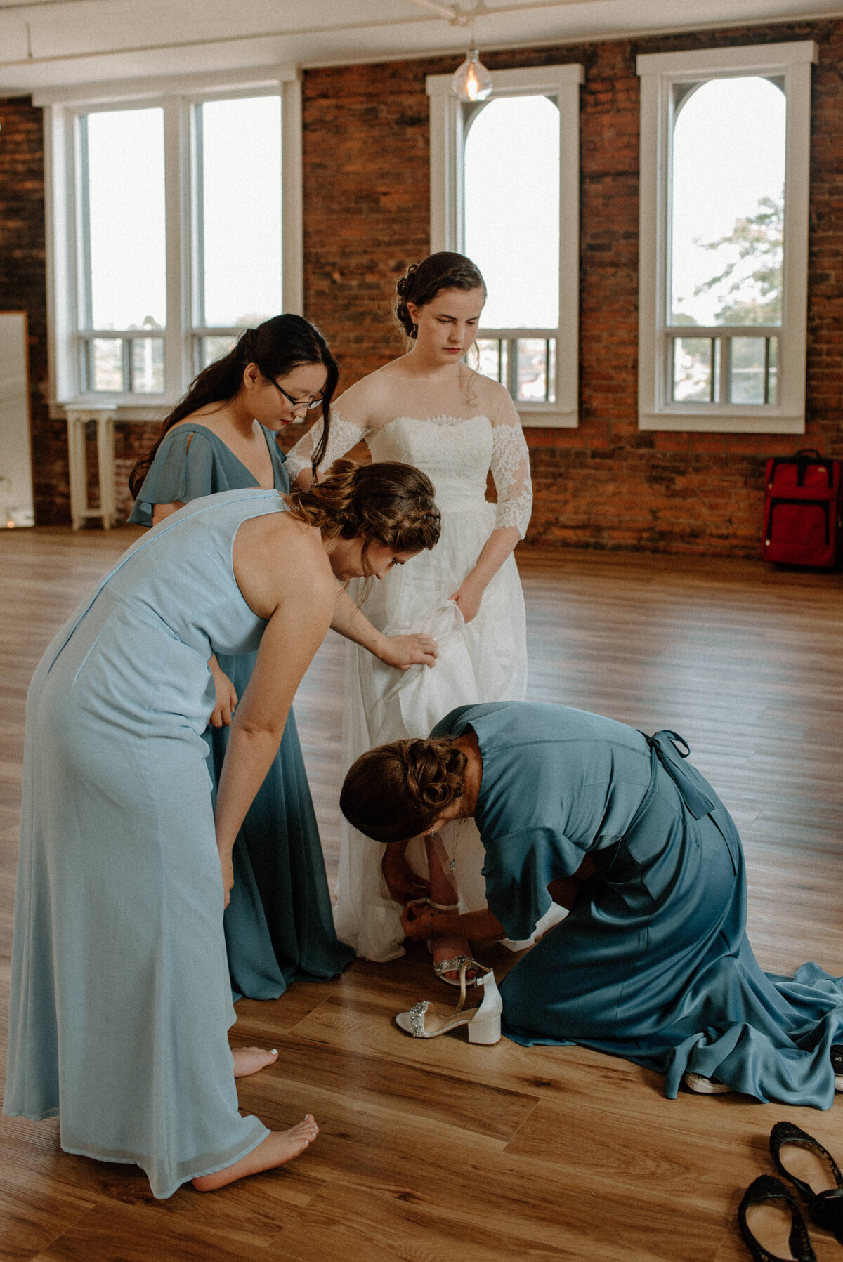 hamilton ontario spice factory wedding bride gets dressed with help of bridesmaids