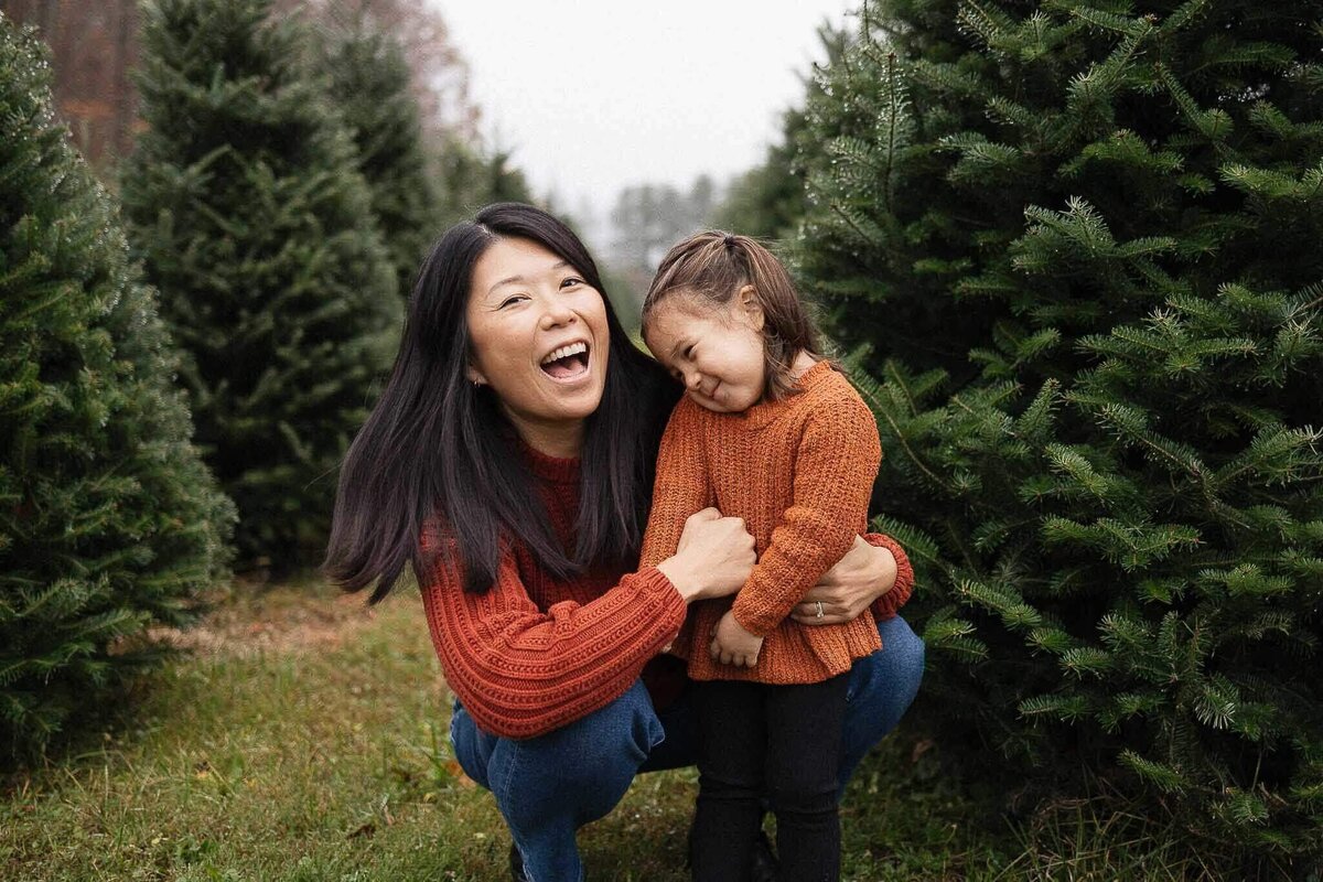 Mom hugging laughing daughter at Sugar Pines Tree Farm in Chesterland, Ohio.