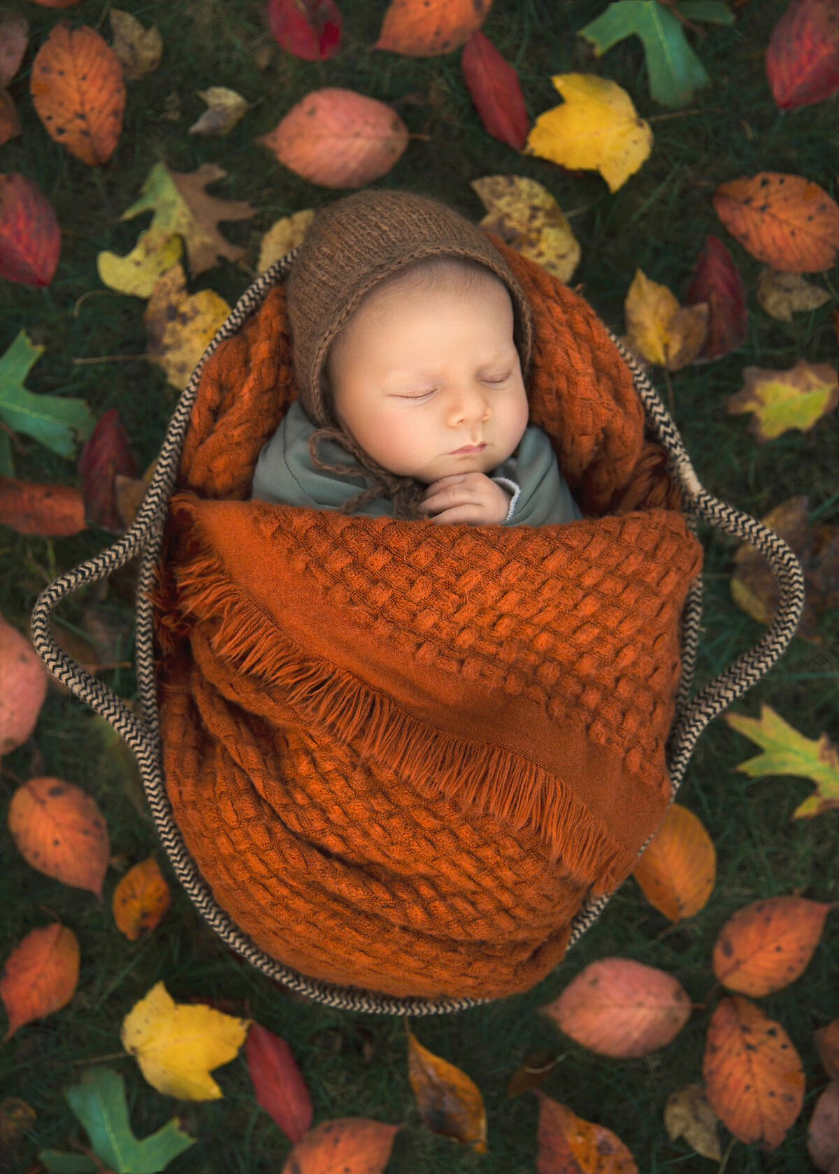 Newborn sleeps for photos, outside during the fall season taken by NJ baby photographer