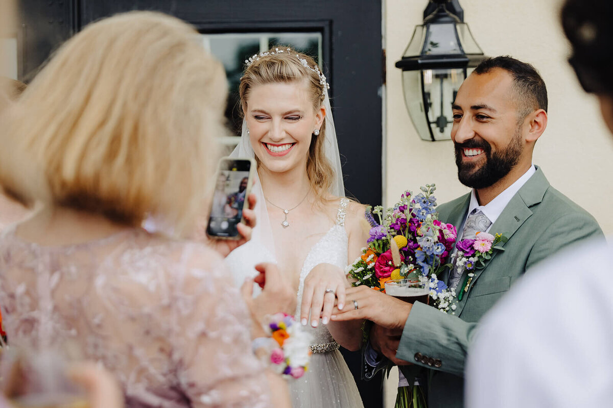 Bride and groom smiling with guest at Keuka Lake wedding