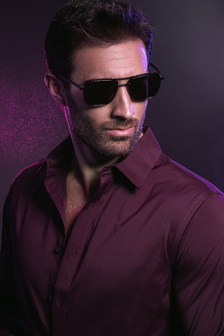 Stylish portrait of Jared wearing sunglasses and a purple shirt, captured by Ylva Erevall.