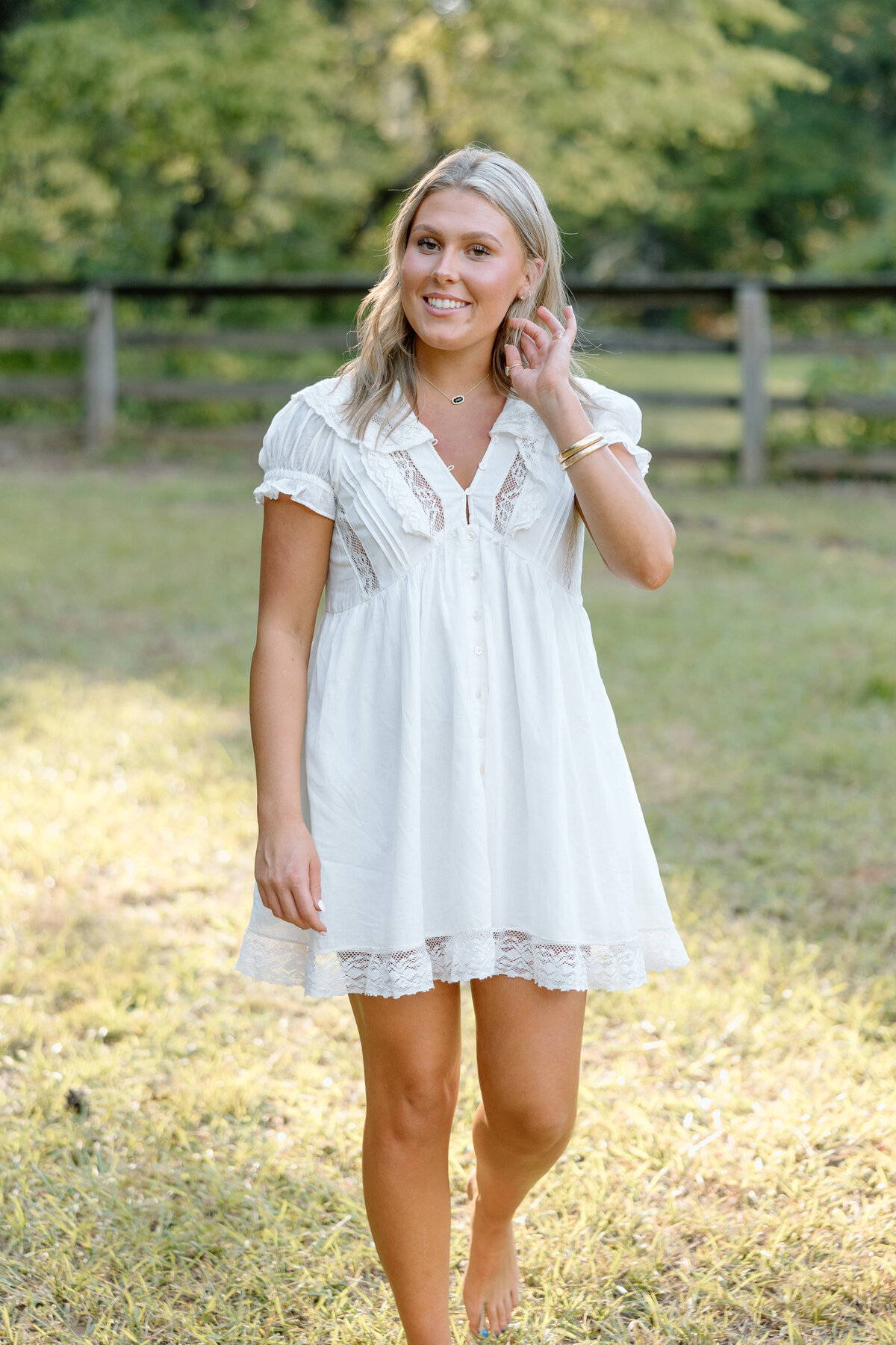 Senior photos at family property, senior tuck hair behind her ear