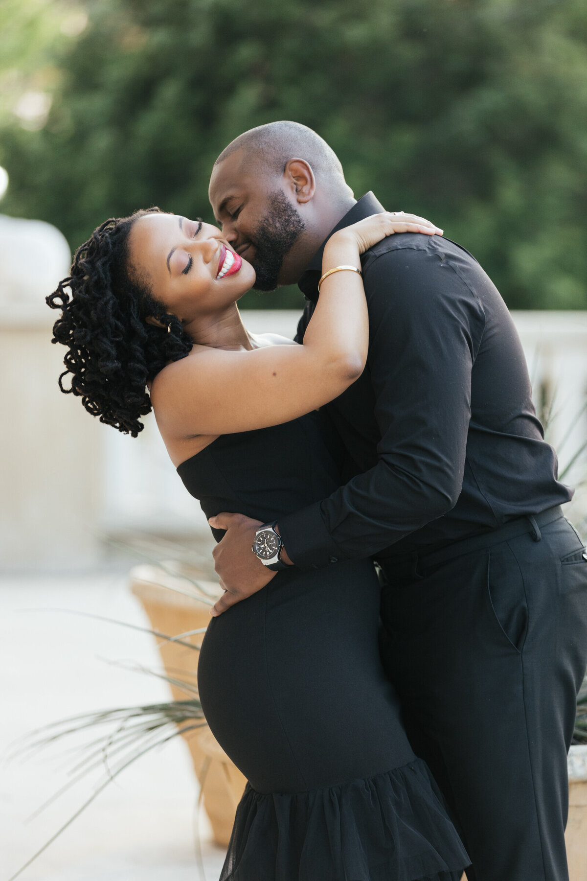 Groom kissing the bride on the cheek as she leans back laughing at sunset in Adriatica Village