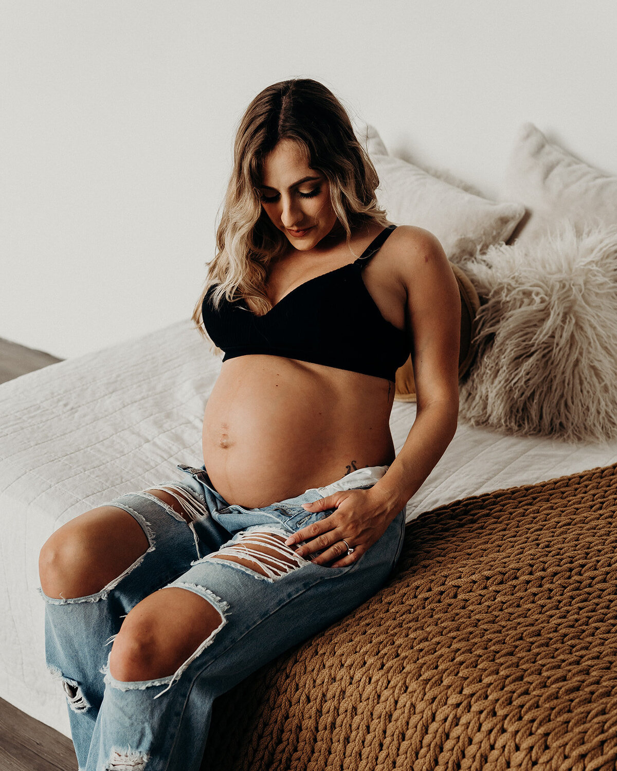 modern maternity photoshoot in black bra and jeans