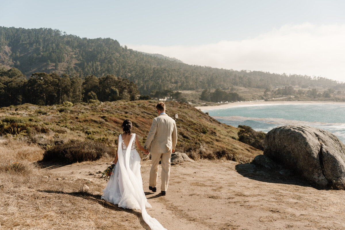 bride and groom walk along carmel coast