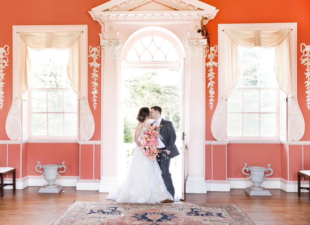 Bride and groom kissing in orange room