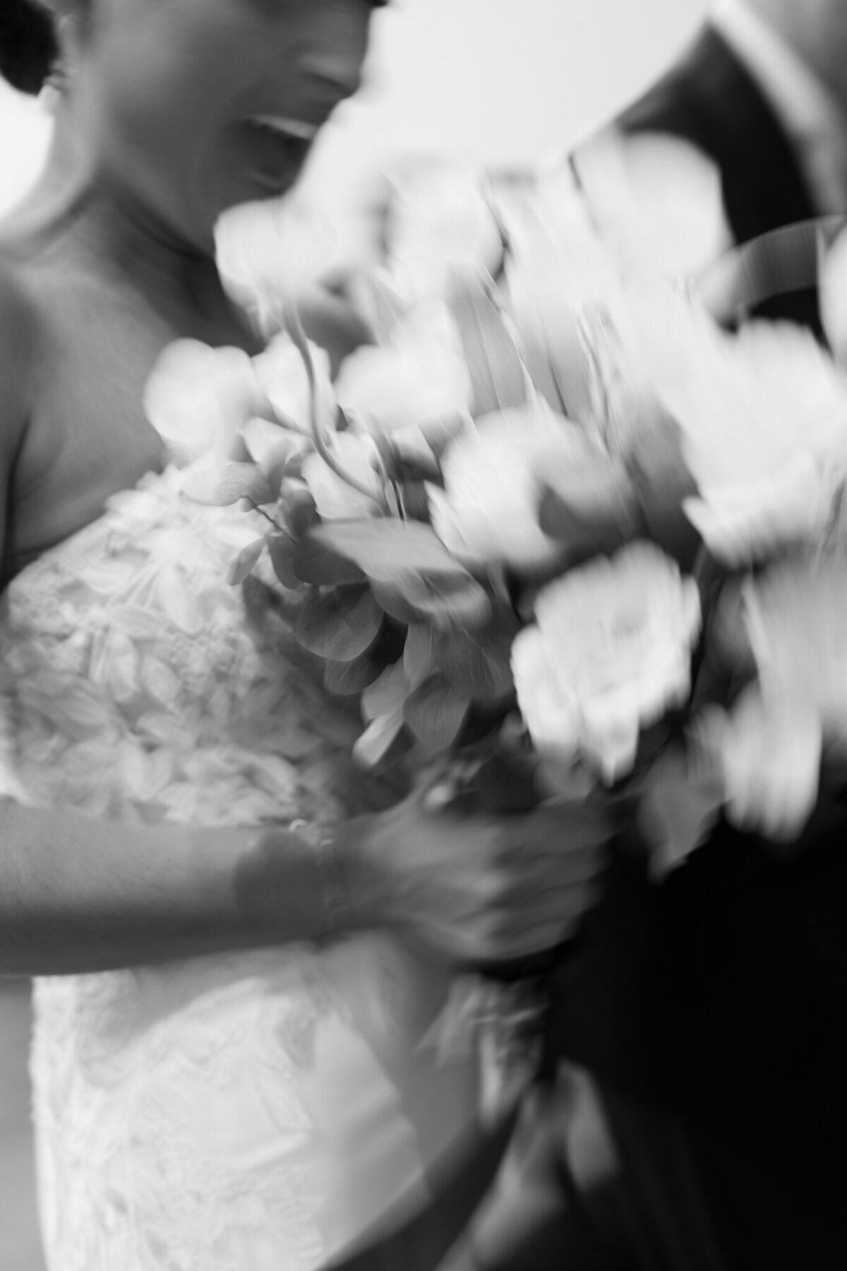 Artistic blurred black and white shot of bride holding bouquet