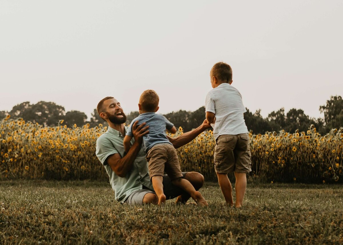 A Pittsburgh family photographer captures a father and his sons playing in a field.