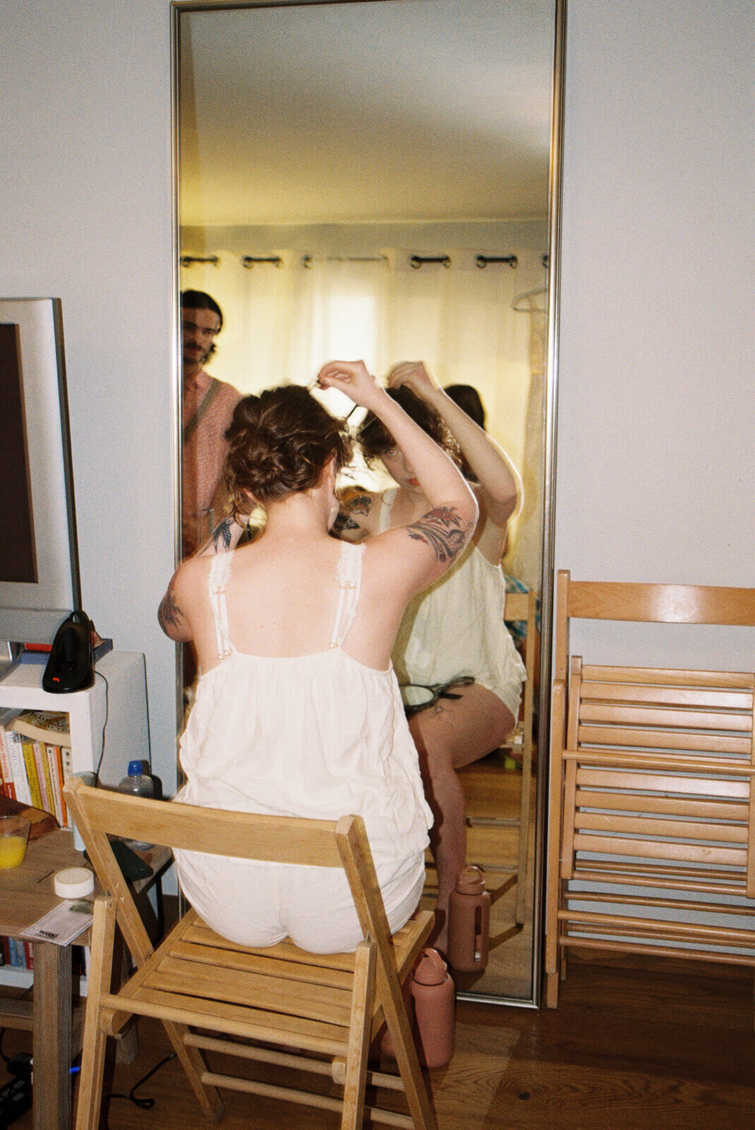 A bride looks in the mirror getting ready.