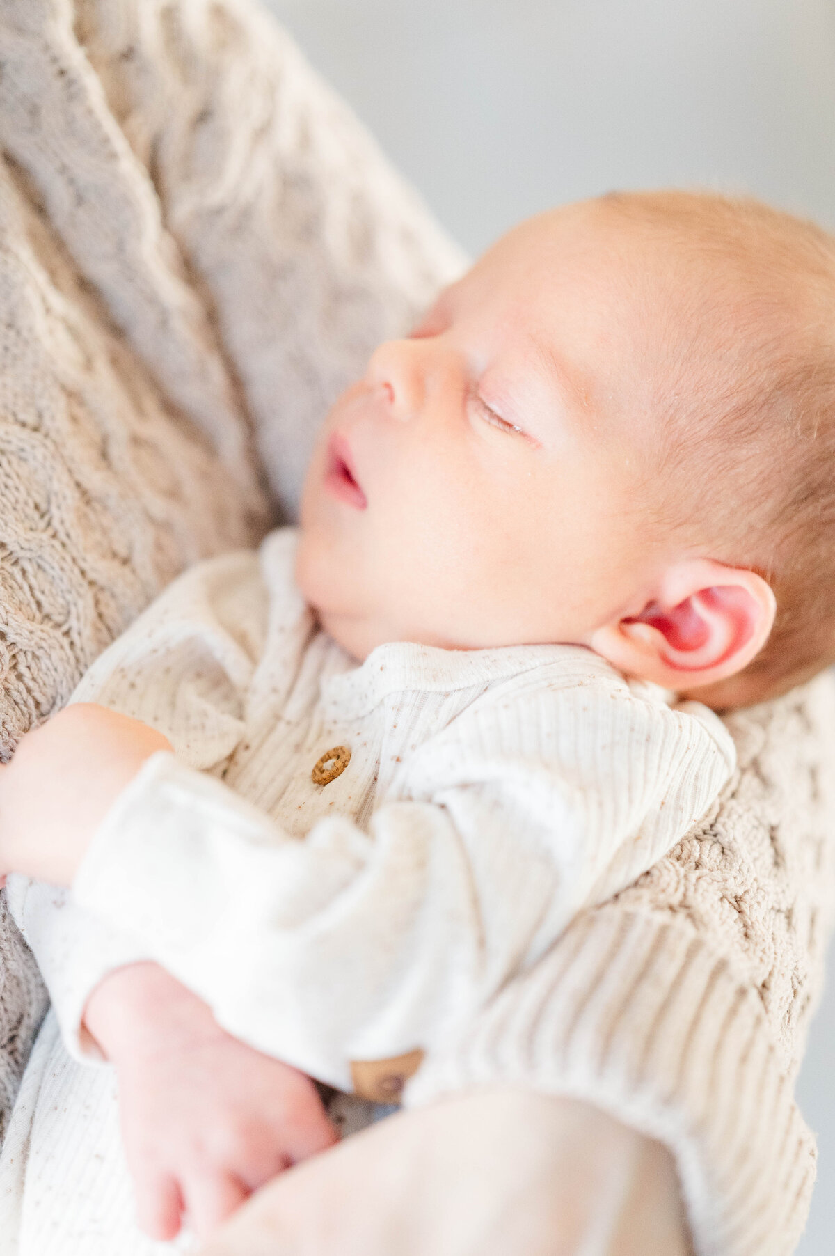 Newborn in mom's arms sleeping taken in Sutton, MA 