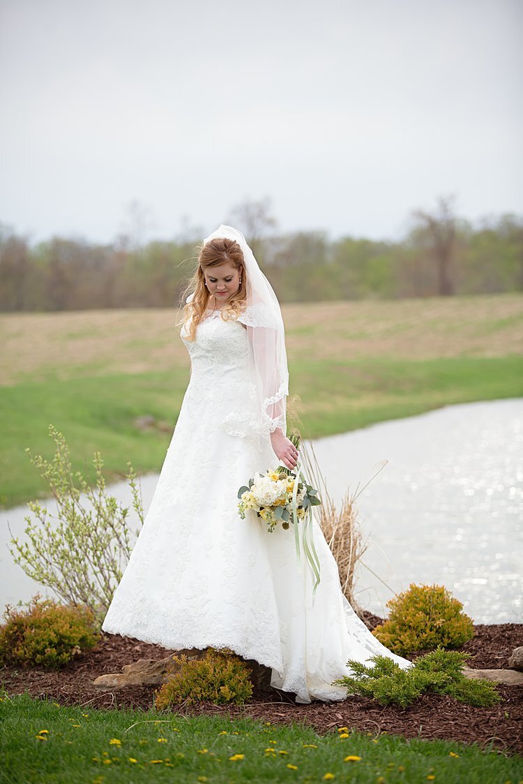 Bridal portrait of bride standing near lake at White Barn in Prospect, PA