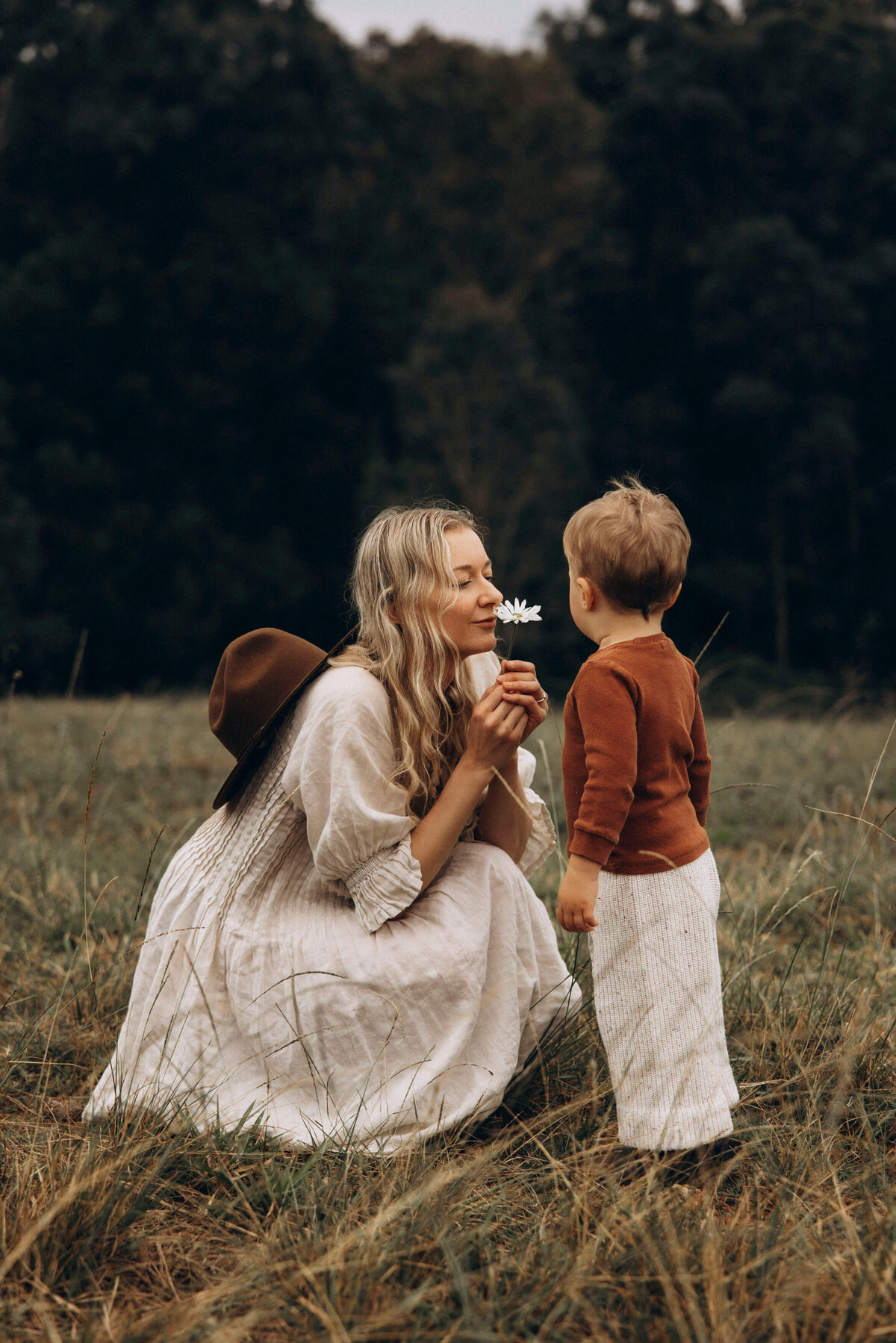 mother and son together with mother semlling a daisy