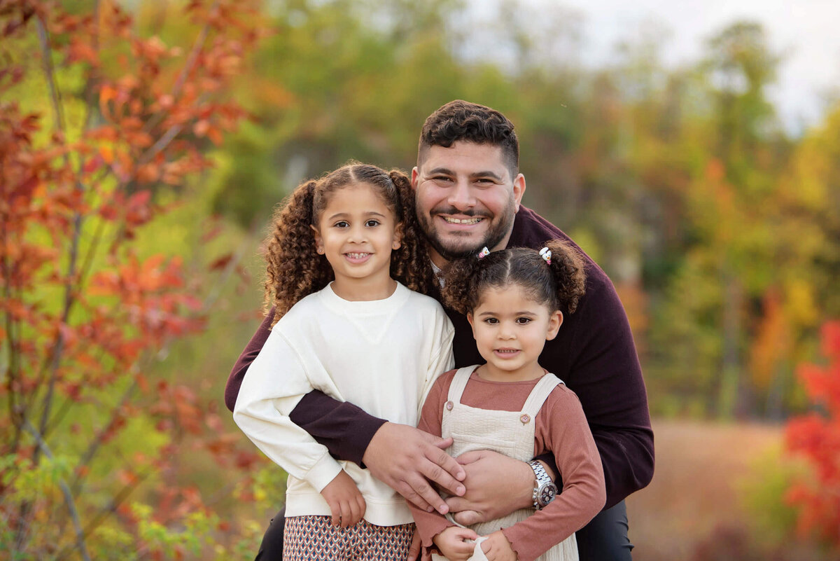 dad hugging his two daughters for their Burlington fall family photos