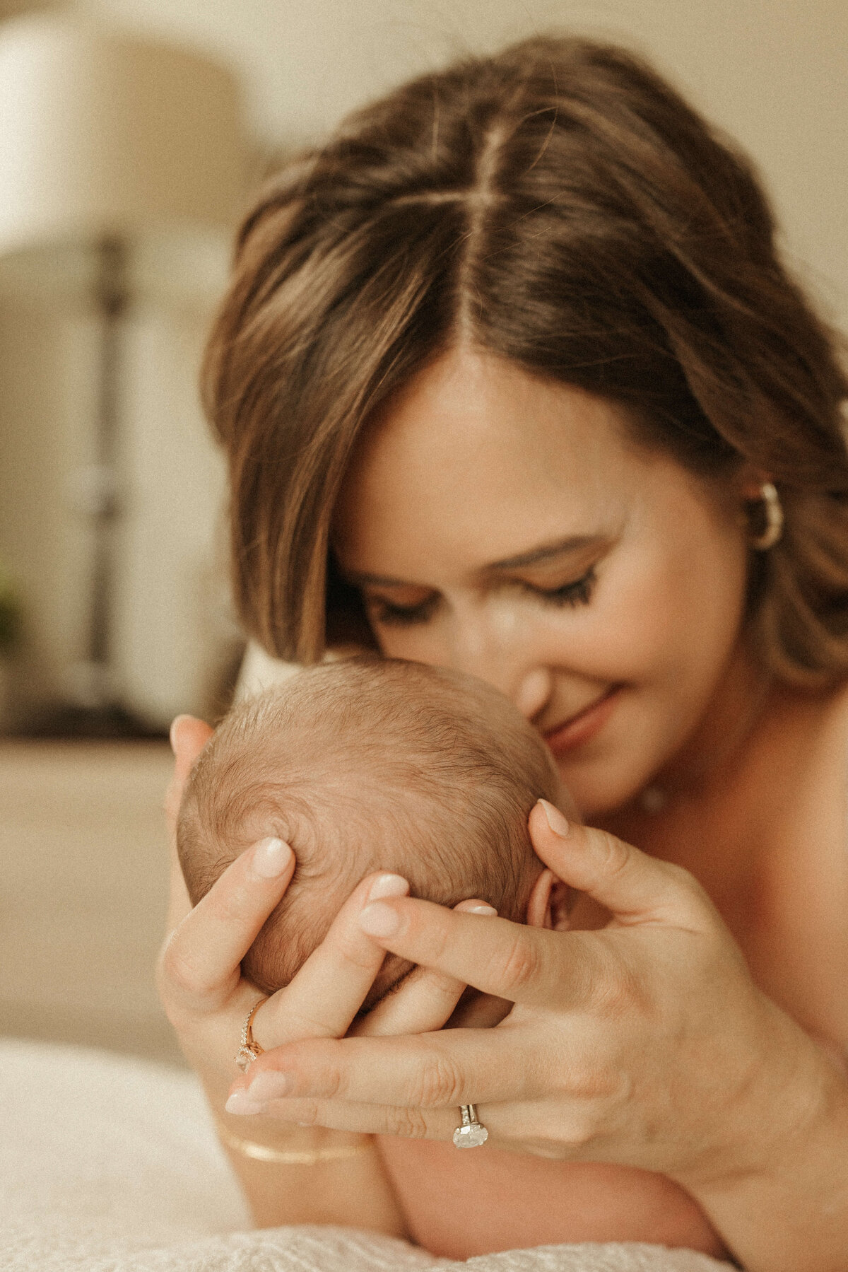 Newborn baby sleeping in parents’ arms during in-home photo session in franklin TN