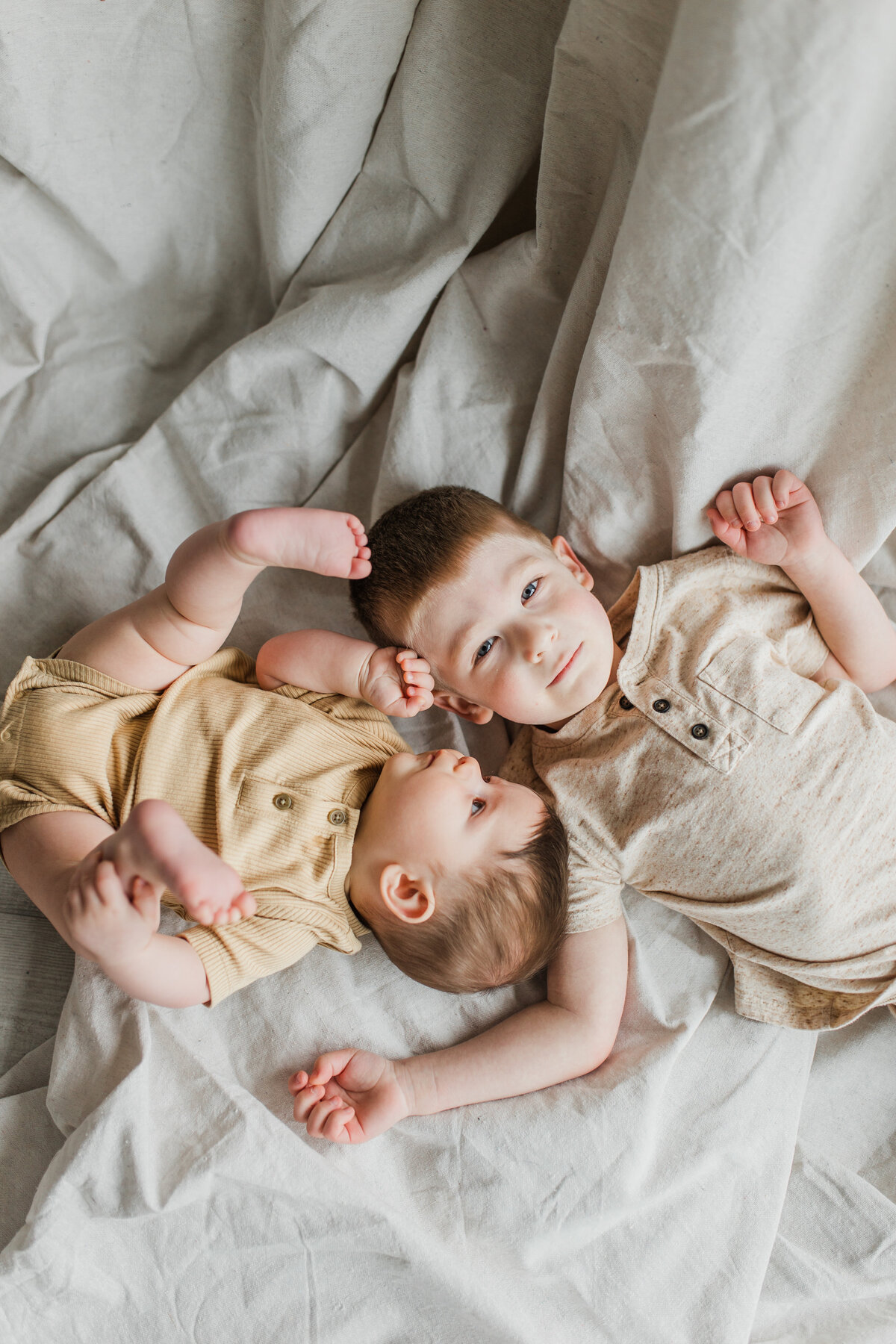 Two children laying down the bed