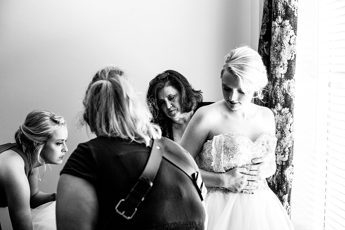 Mahlia helping brides family button the wedding dress