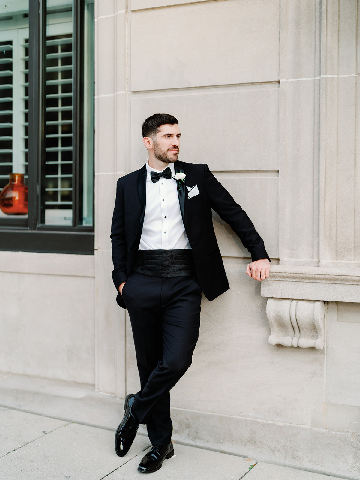 Groom looking left and leaning againt the wall at Hotel washington.